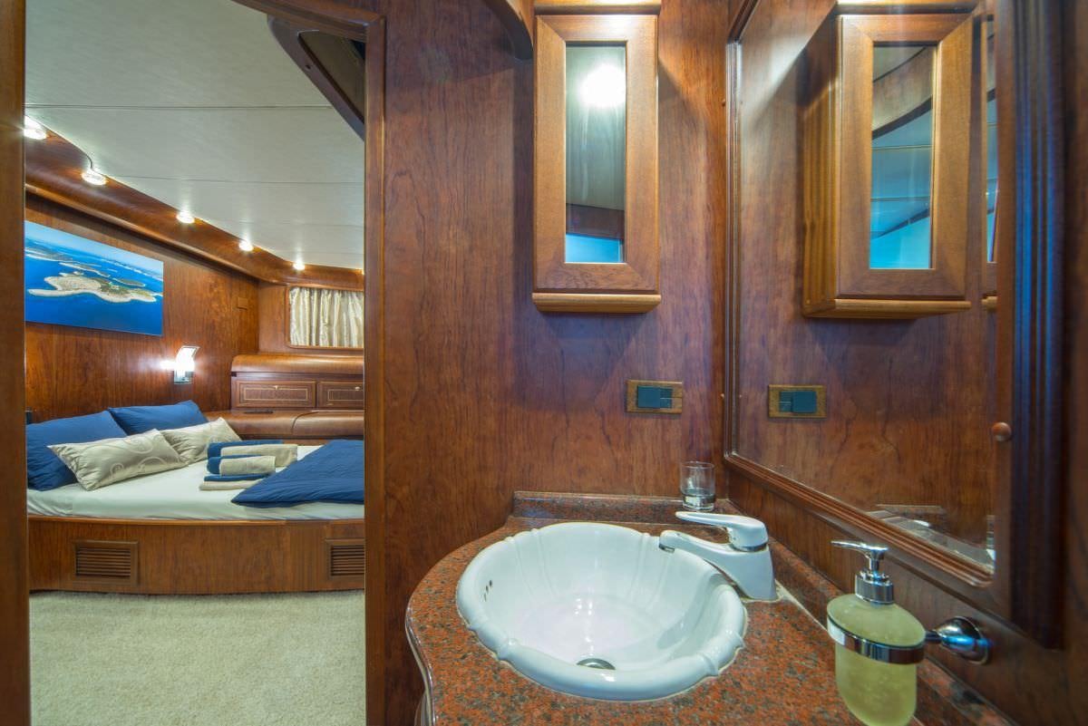 a bathroom with a sink and a bed aboard ALBA Yacht for Charter