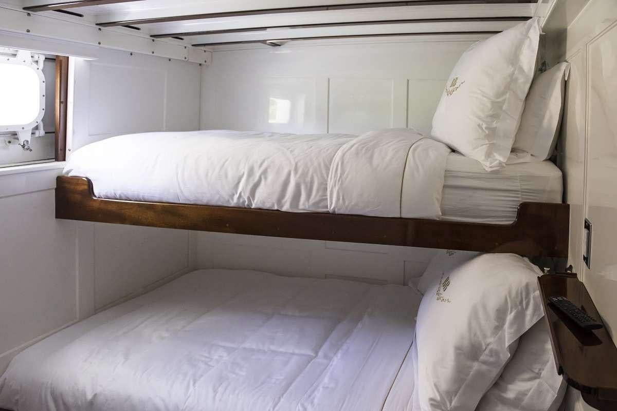 a bed with white sheets aboard BB Yacht for Charter