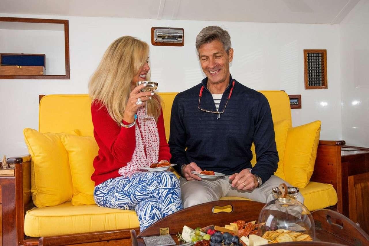 a man and woman sitting on a couch aboard BB Yacht for Charter