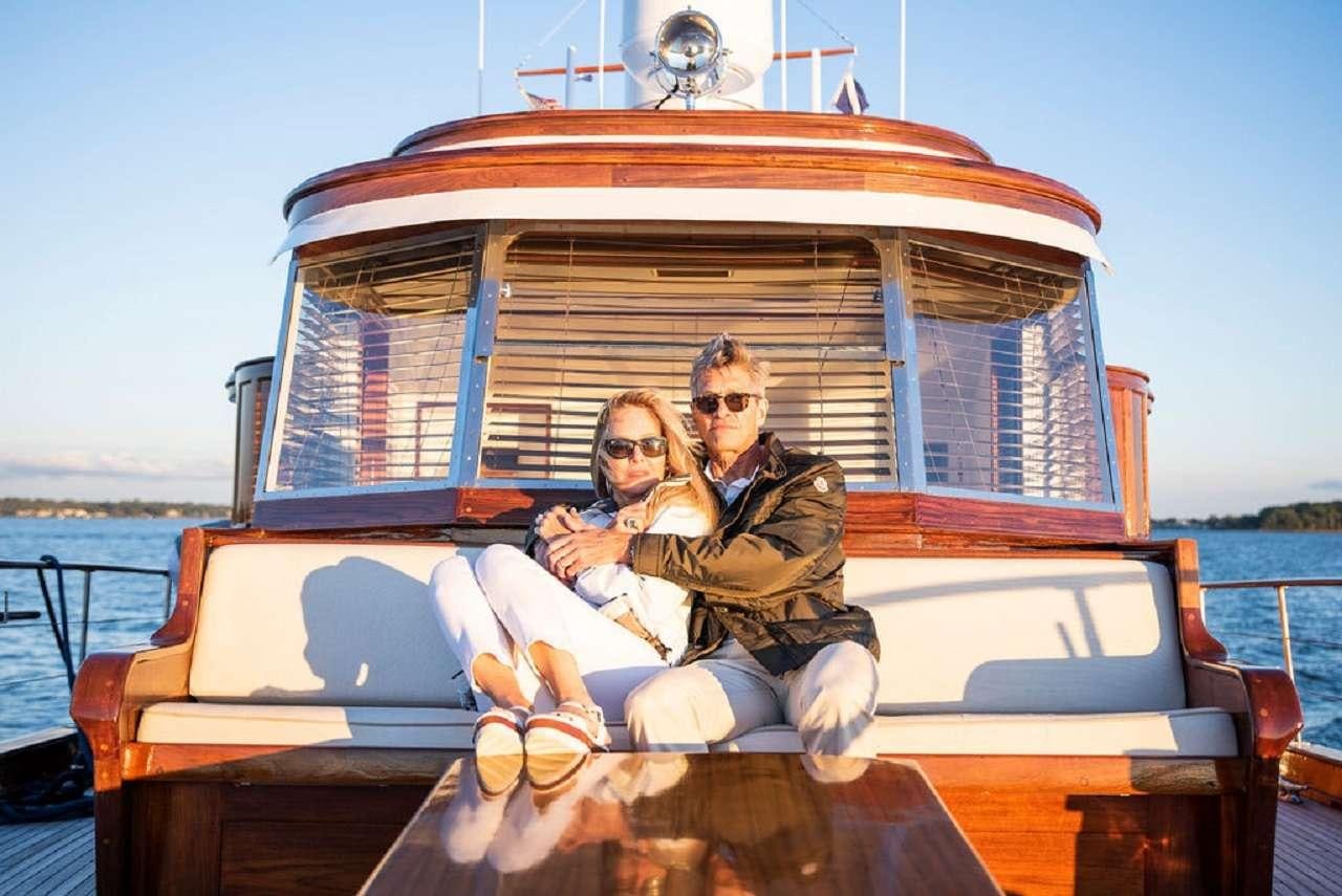 a man and woman sitting on a boat aboard BB Yacht for Charter