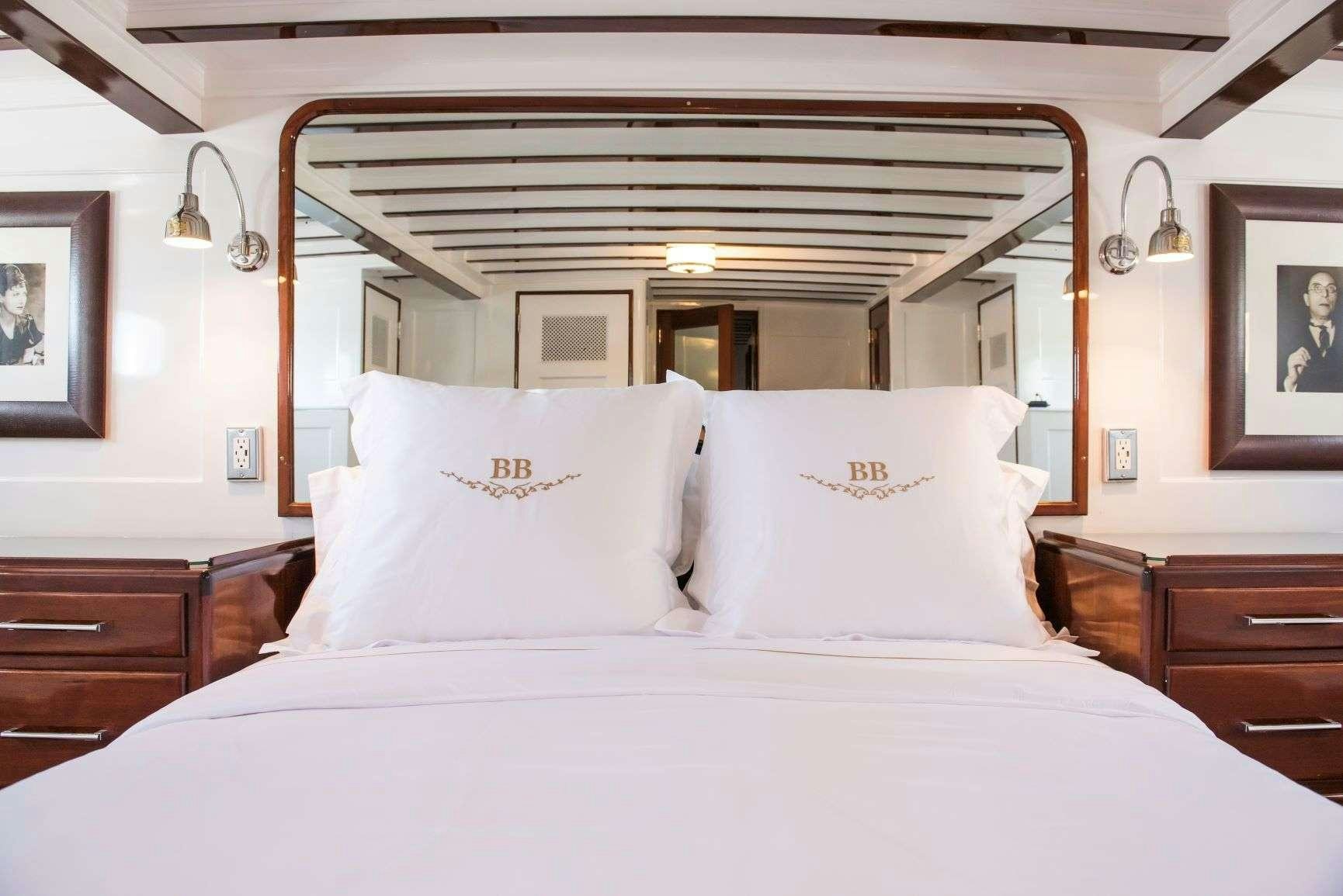 a bed with white sheets aboard BB Yacht for Charter
