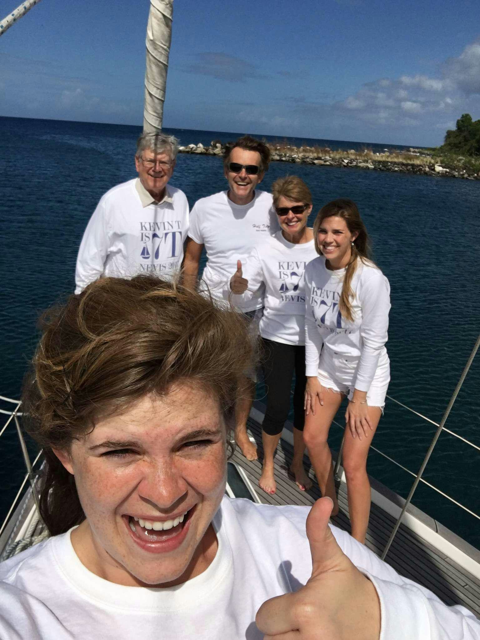 a group of people posing for a photo on a boat aboard HALF TIDY Yacht for Charter