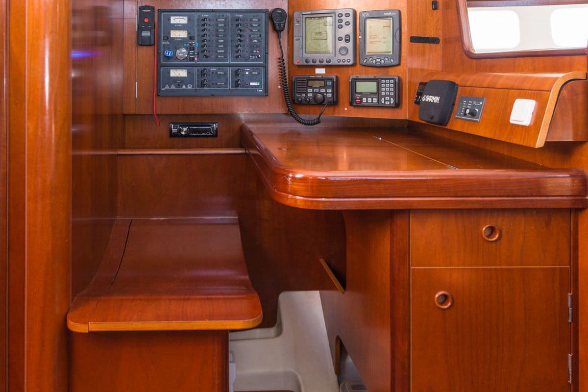 a wooden desk with a phone and a computer on it aboard HALF TIDY Yacht for Charter