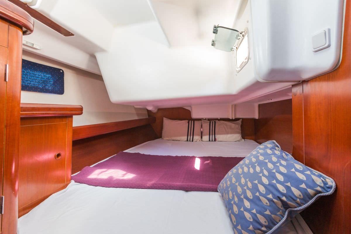a room with a bed and a desk aboard HALF TIDY Yacht for Charter