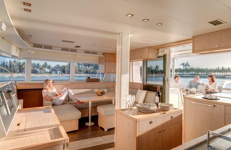a family sits in the living room aboard LAGOON 52 Yacht for Charter
