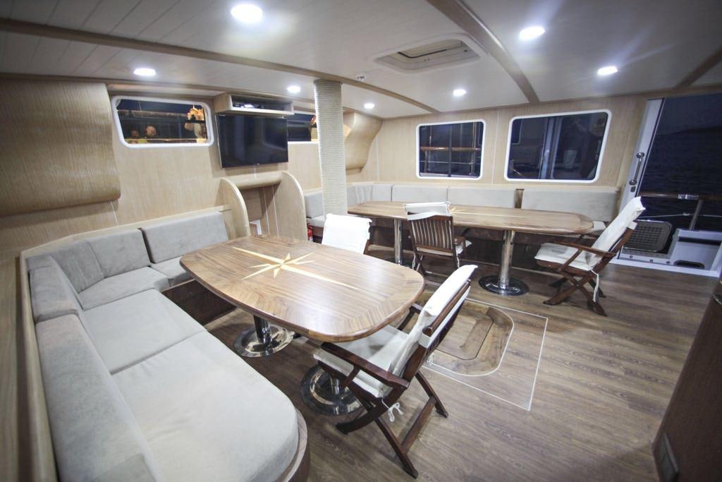 a room with tables and chairs aboard OGUZBEY Yacht for Charter