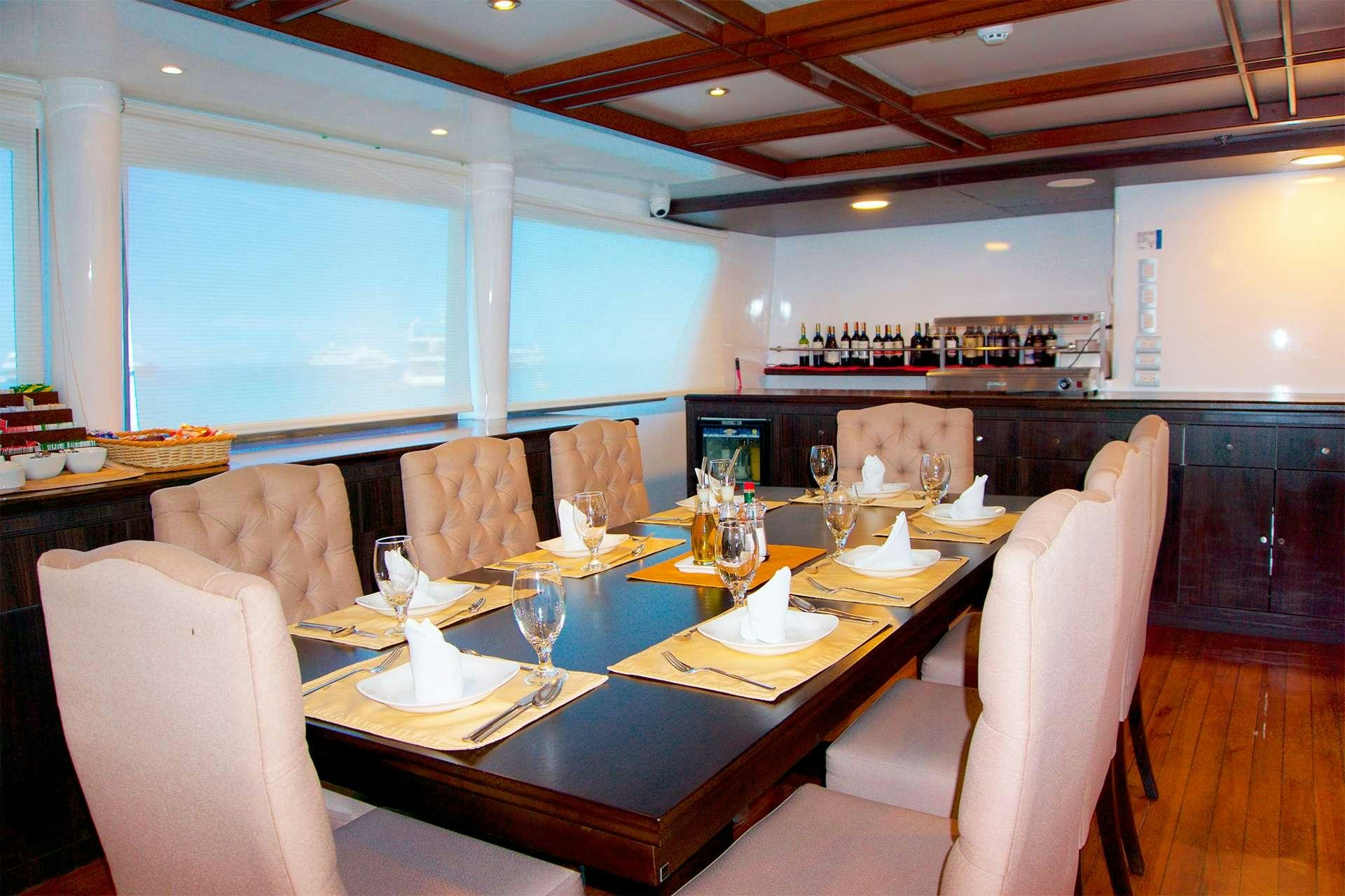 a large dining room with a table and chairs aboard CORMORANT Yacht for Charter