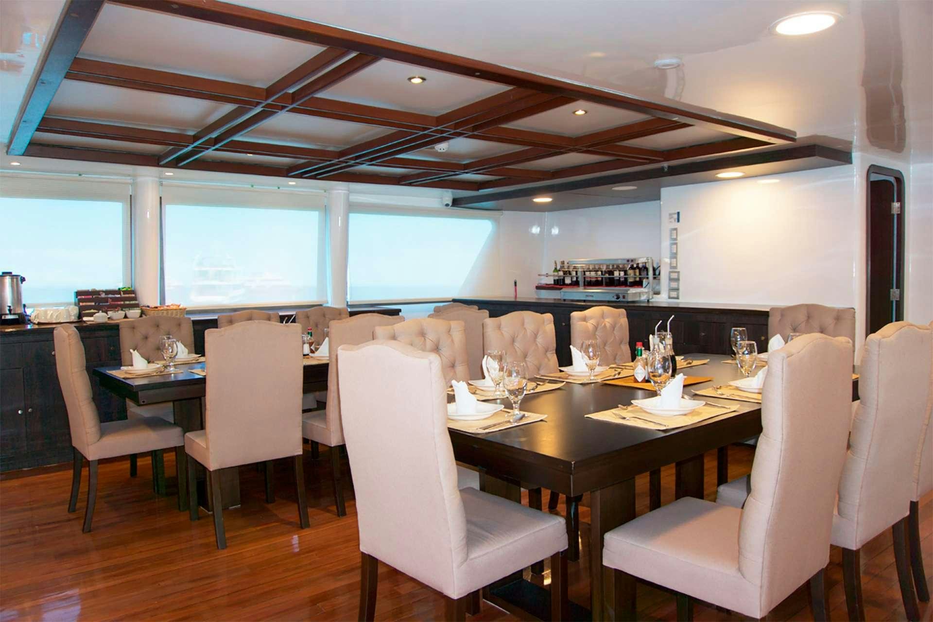 a large room with a table and chairs aboard CORMORANT Yacht for Charter