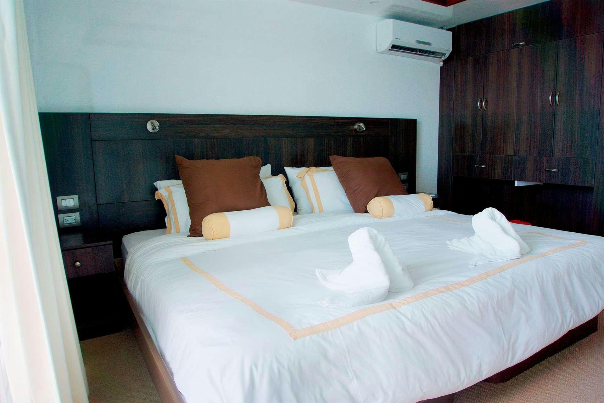 a bed with white sheets and pillows aboard CORMORANT Yacht for Charter