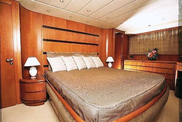 a bed with a wooden headboard aboard ABSOLUTE KING Yacht for Charter