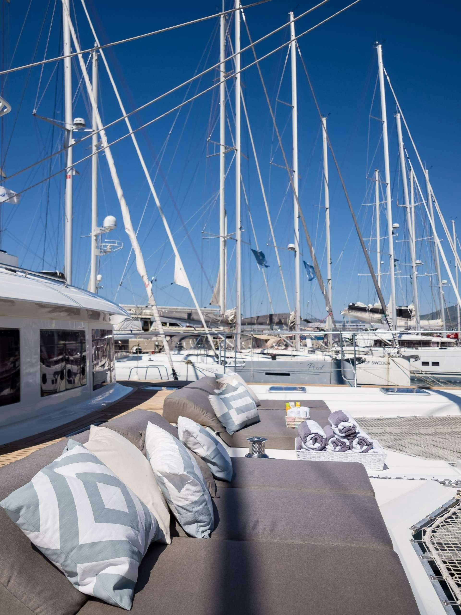 a boat dock with a boat and a couch aboard TWIN Yacht for Charter
