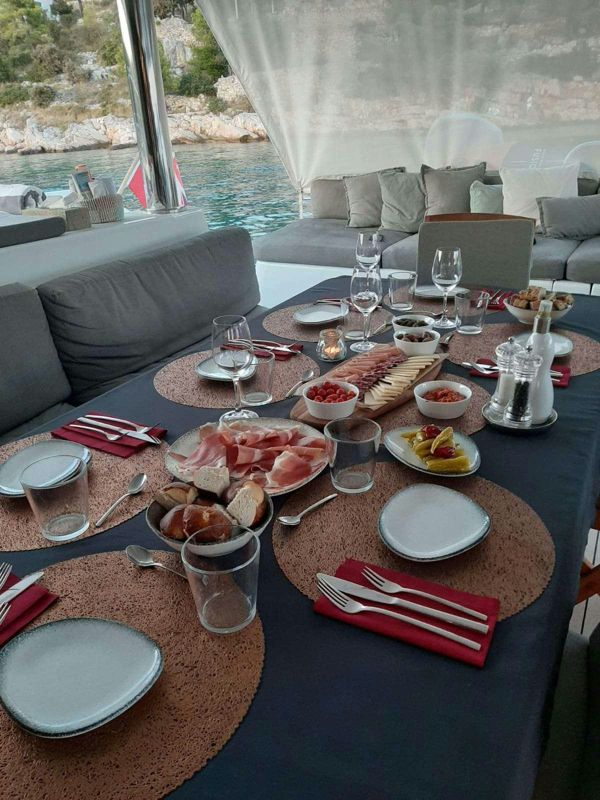 a table with plates and glasses aboard TWIN Yacht for Charter