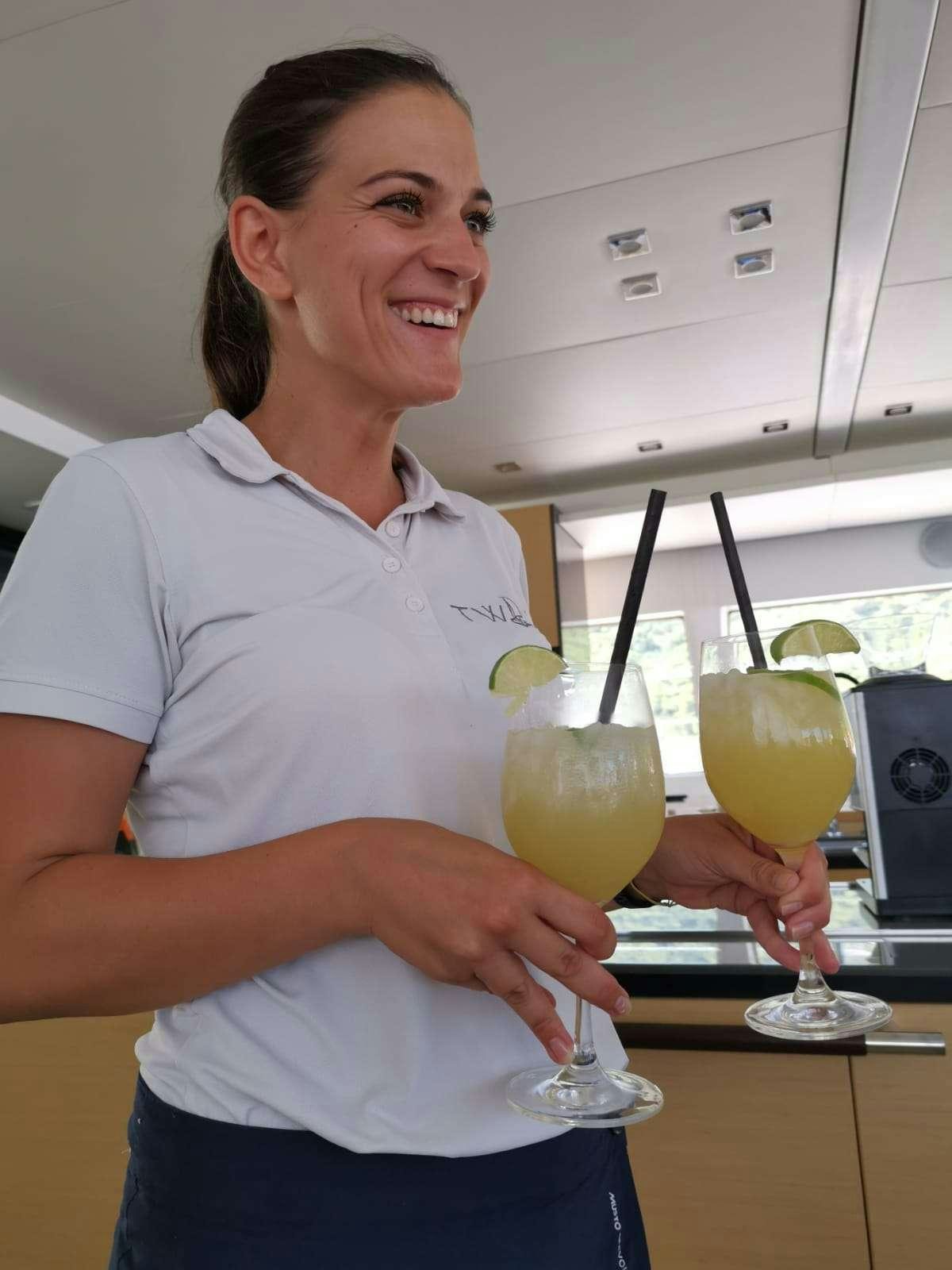 Claudia Zanella holding a glass of liquid aboard TWIN Yacht for Charter