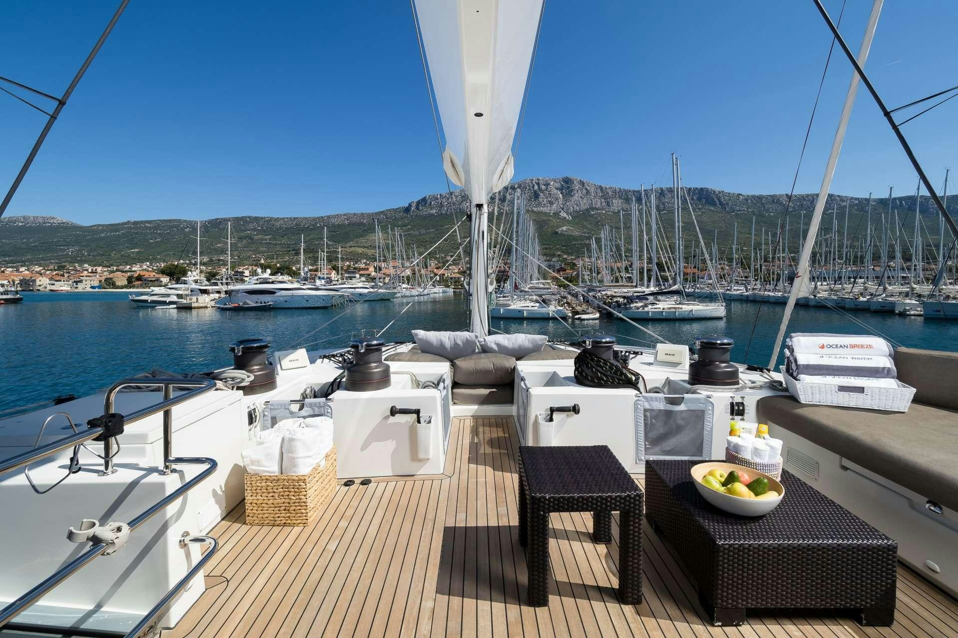 a deck with a table and chairs on it and a view of a city and water aboard TWIN Yacht for Charter