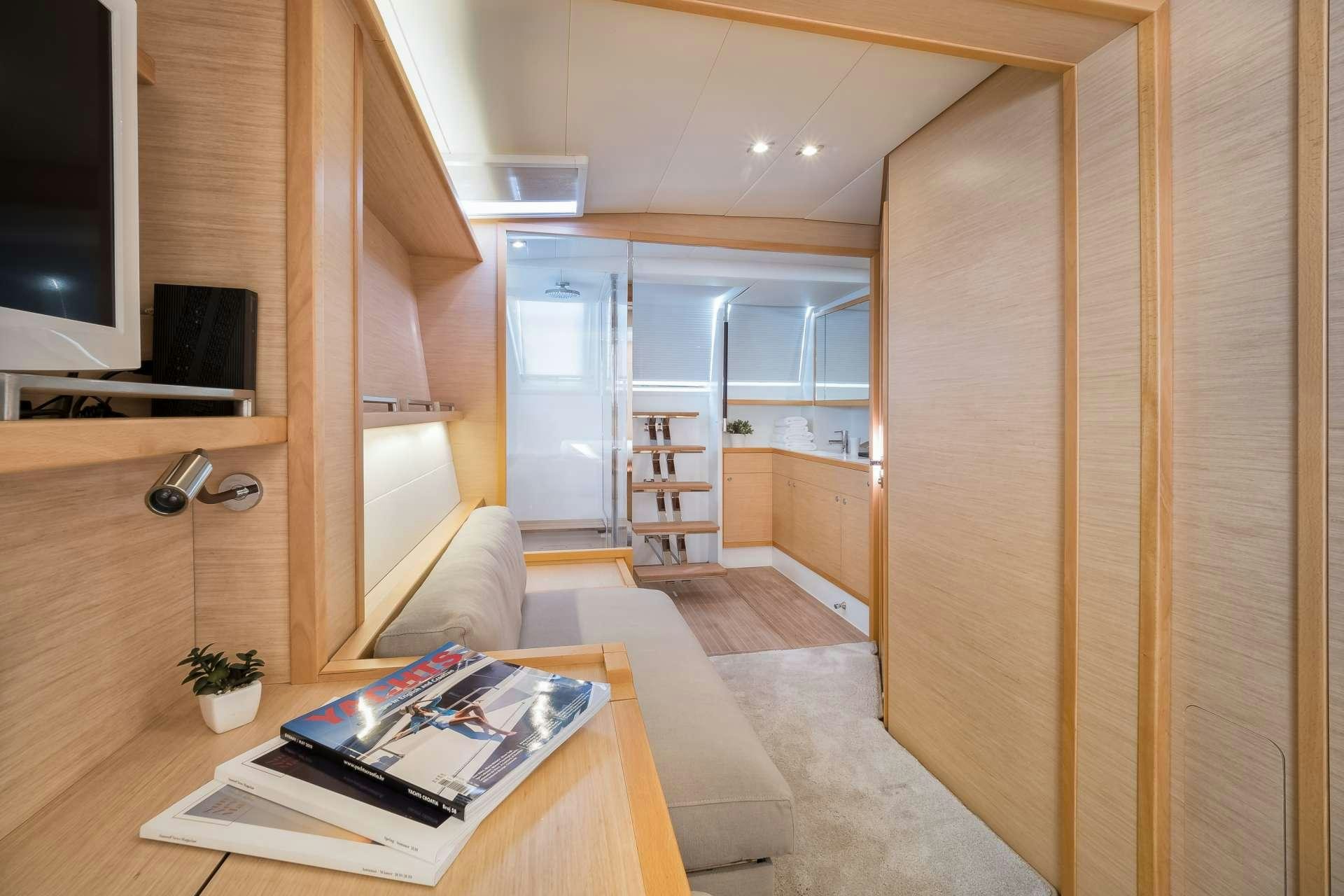 a room with a couch and a tv aboard TWIN Yacht for Charter