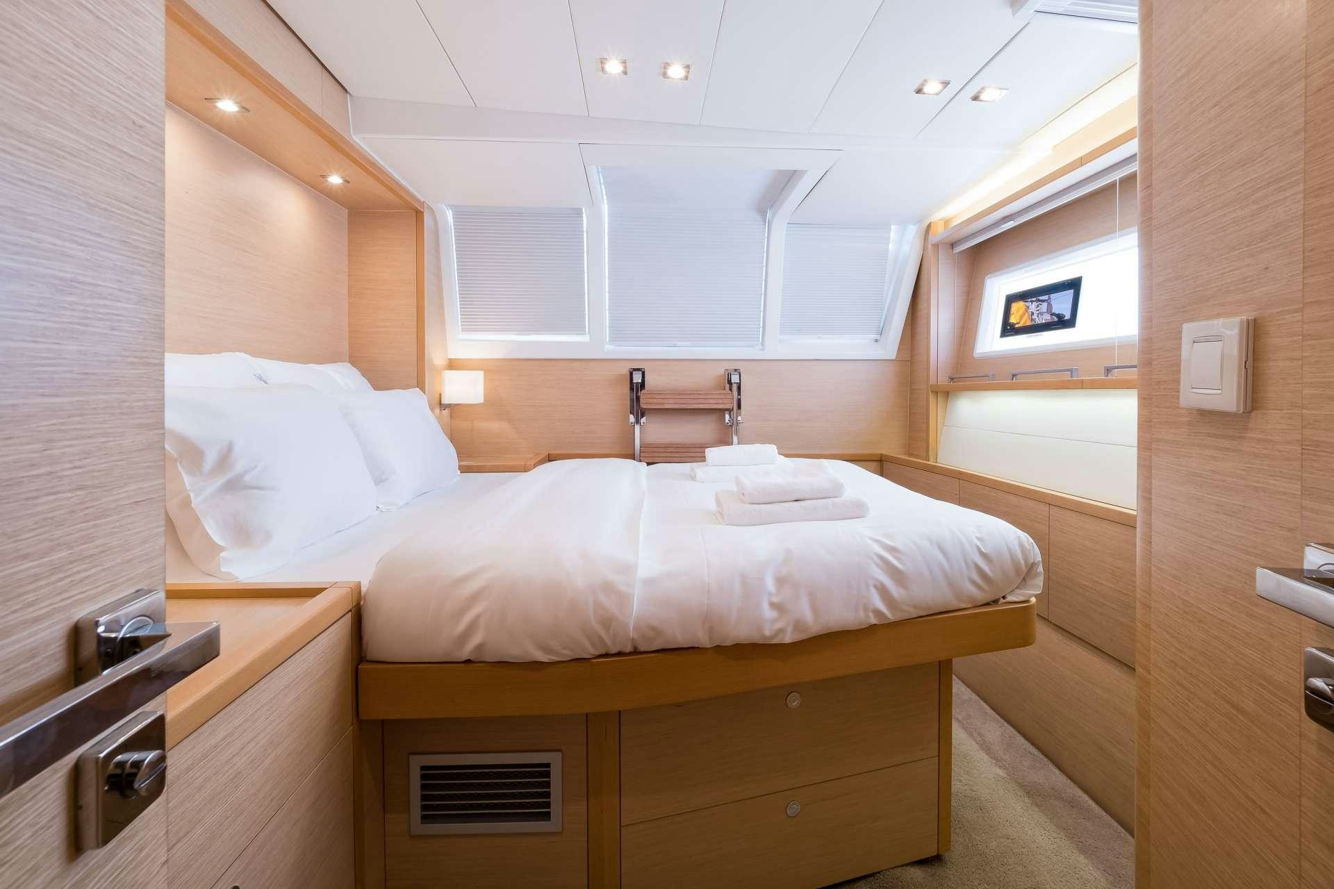 a room with a bed and a sink aboard TWIN Yacht for Charter