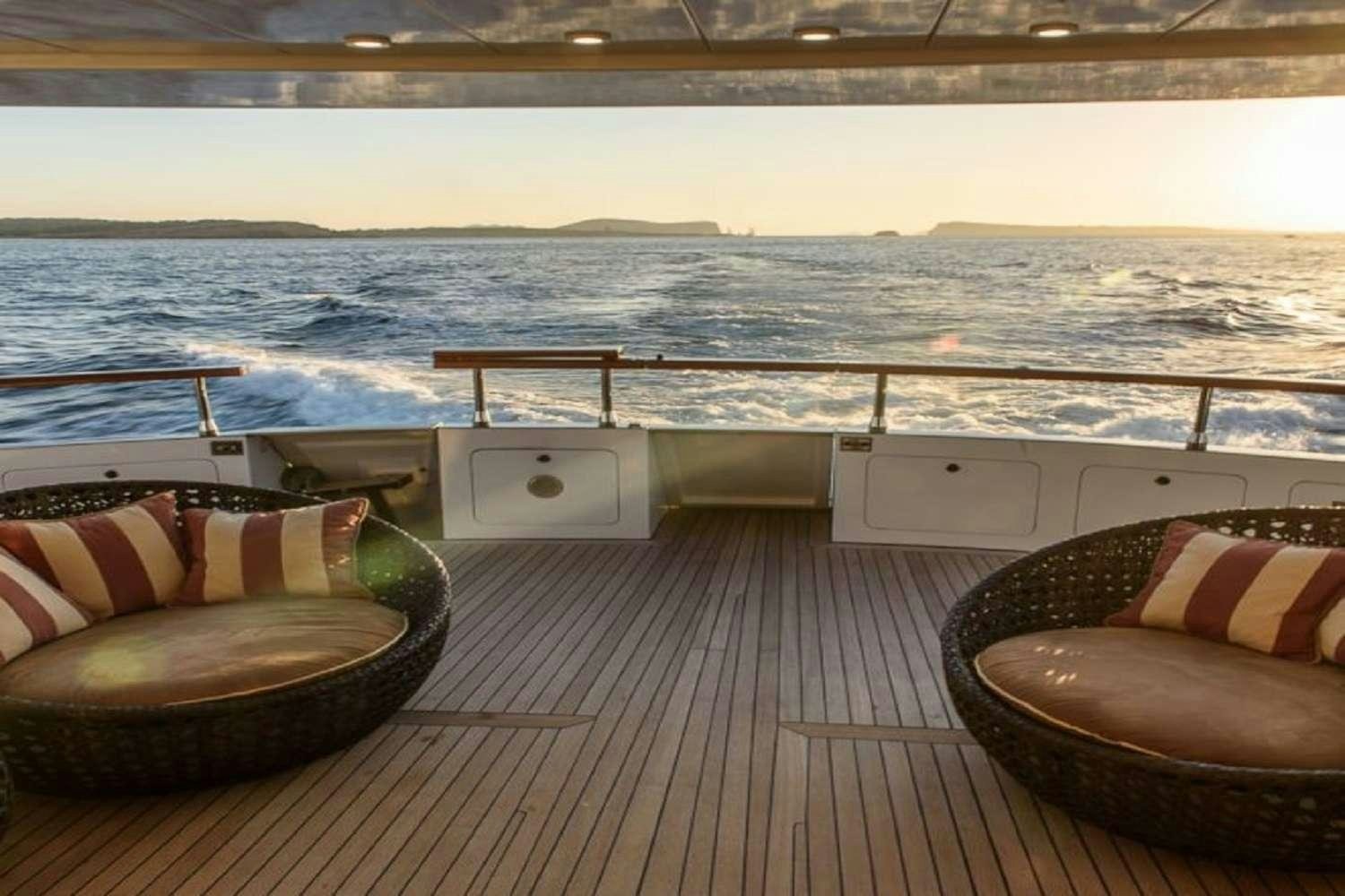 a deck with a view of the ocean and a boat aboard PAULA III Yacht for Charter