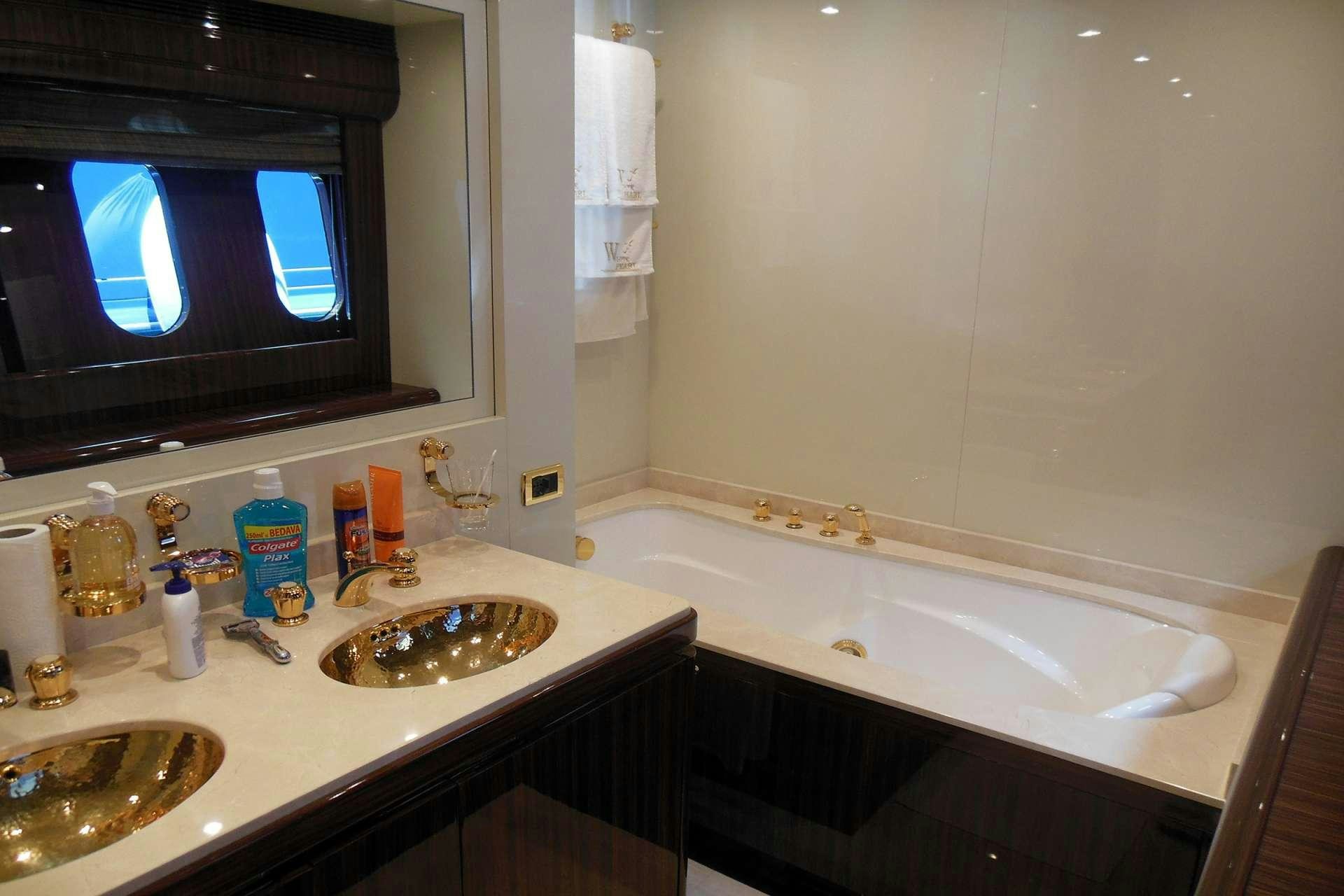 a bathroom with a tv and bathtub aboard WHITE PEARL Yacht for Charter