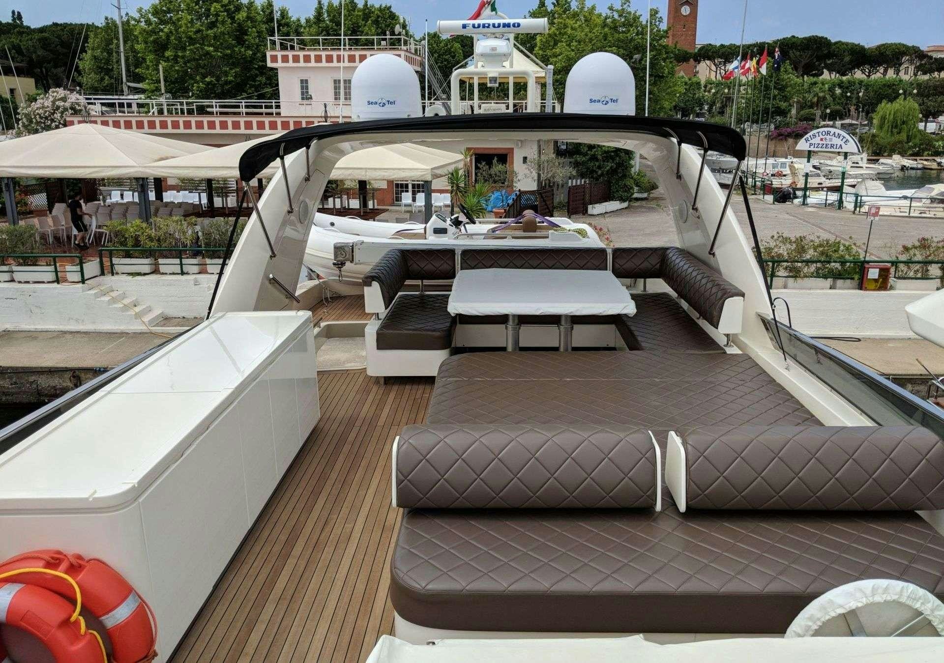 a deck with a table and chairs aboard ARMA VII Yacht for Charter