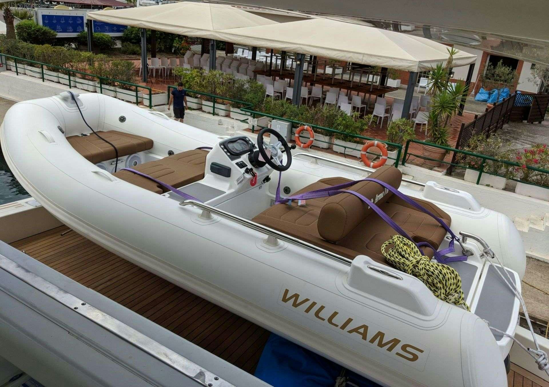 a white boat with a red and blue rope tied to it aboard ARMA VII Yacht for Charter