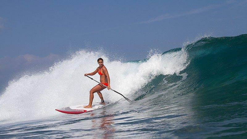 a man surfing on a wave aboard AURORA Yacht for Charter