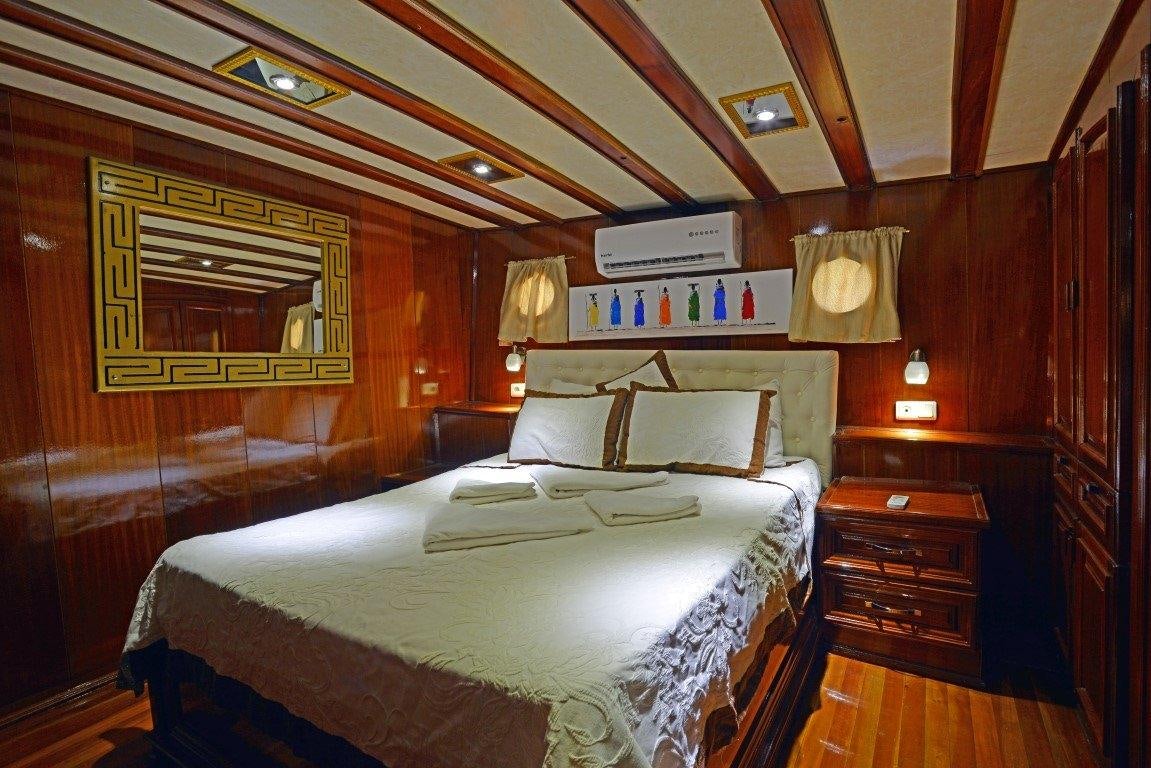 a bedroom with a bed and a desk aboard HOLIDAY X Yacht for Charter