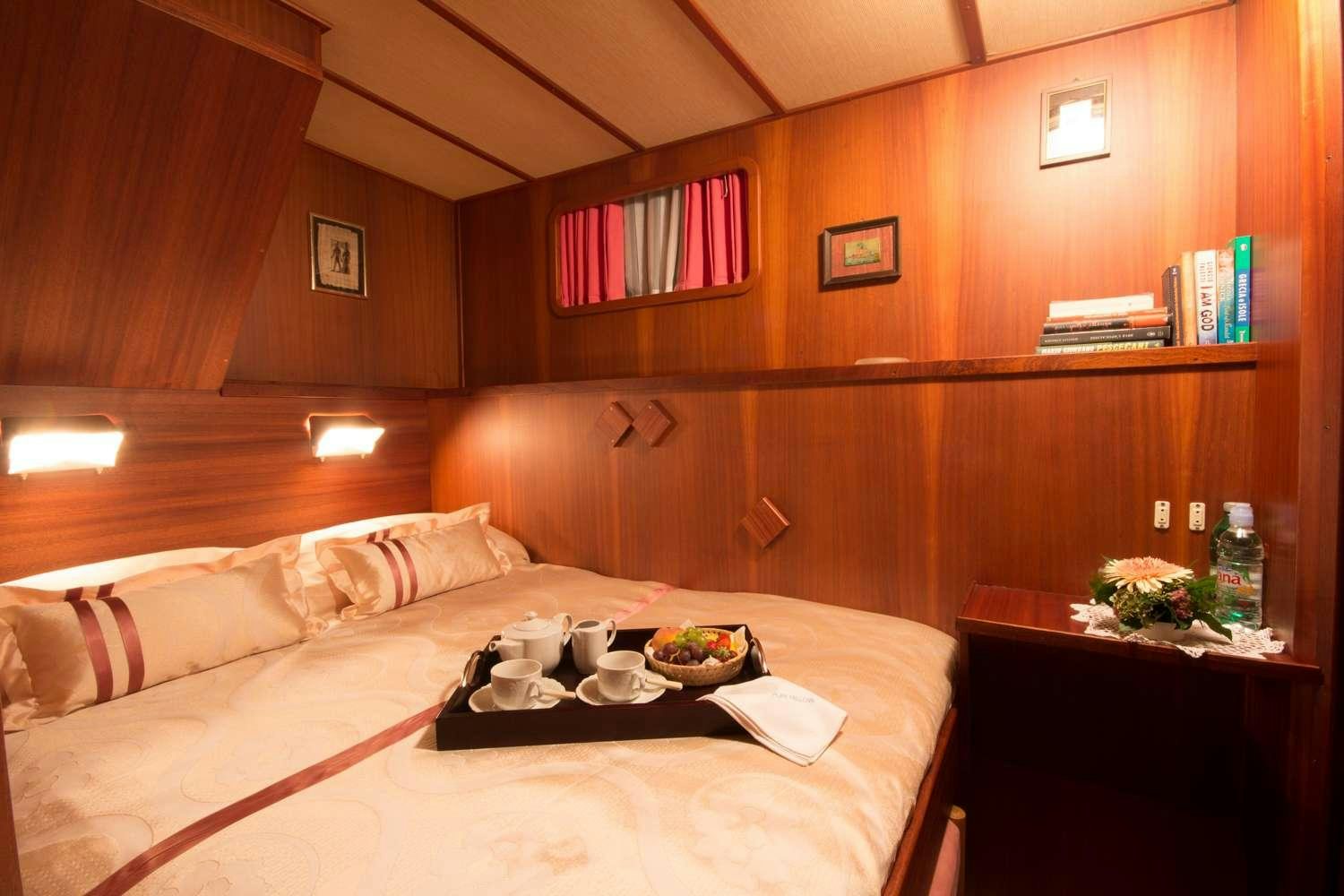 a room with a bed and a table aboard Play Fellow Yacht for Charter