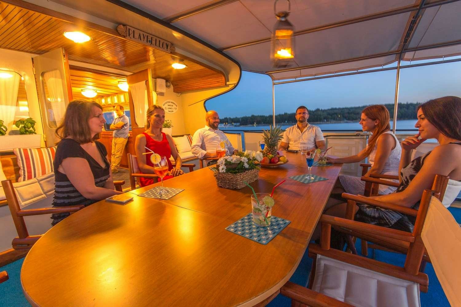 people sitting at tables in a restaurant aboard Play Fellow Yacht for Charter