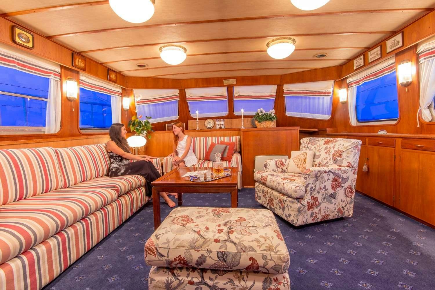 a group of people sitting in a living room aboard Play Fellow Yacht for Charter