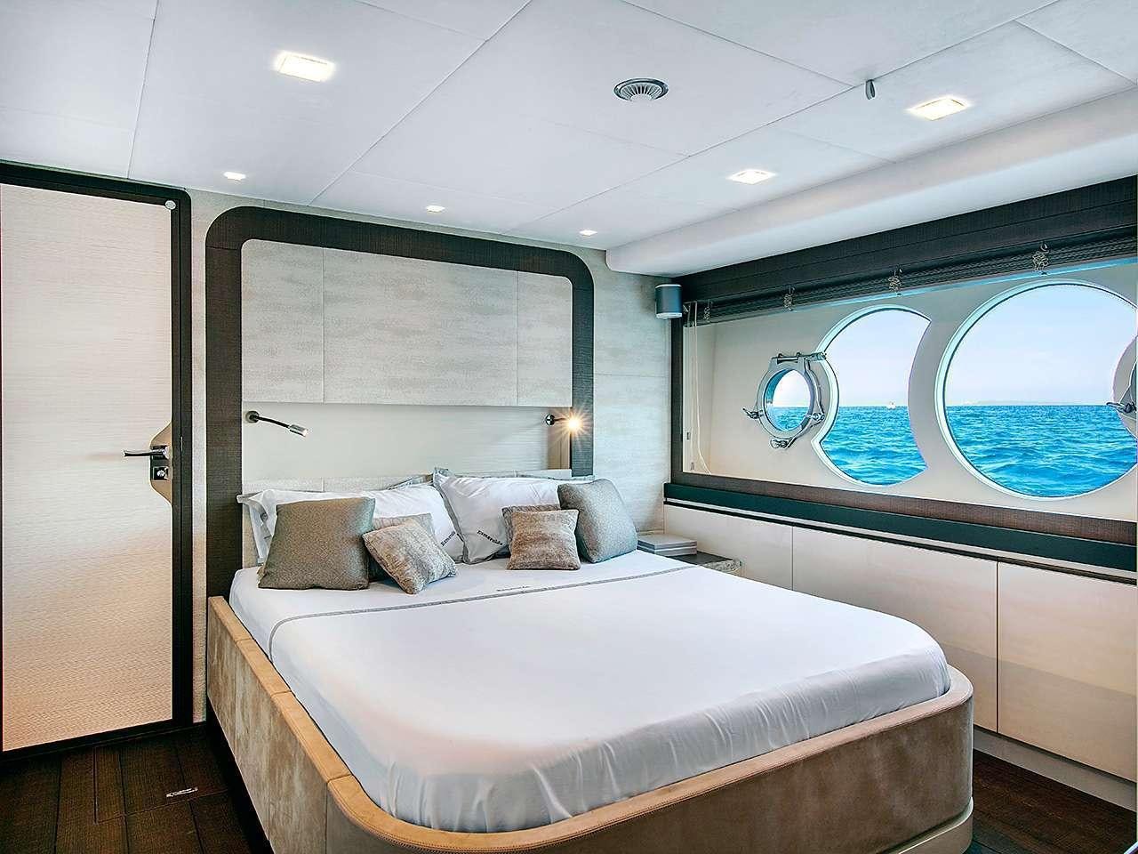 a bedroom with a bed and a window aboard ESMERALDA OF THE SEAS Yacht for Charter