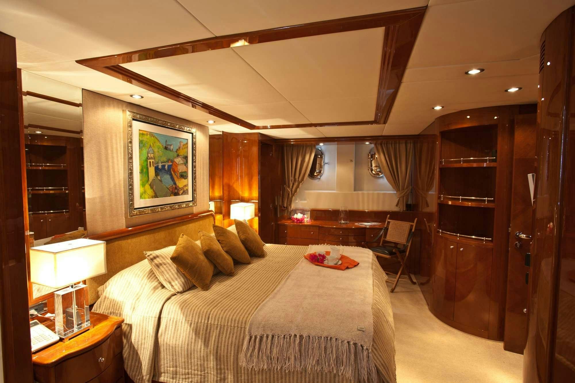 a hotel room with a bed and a desk aboard SUPER Yacht for Charter