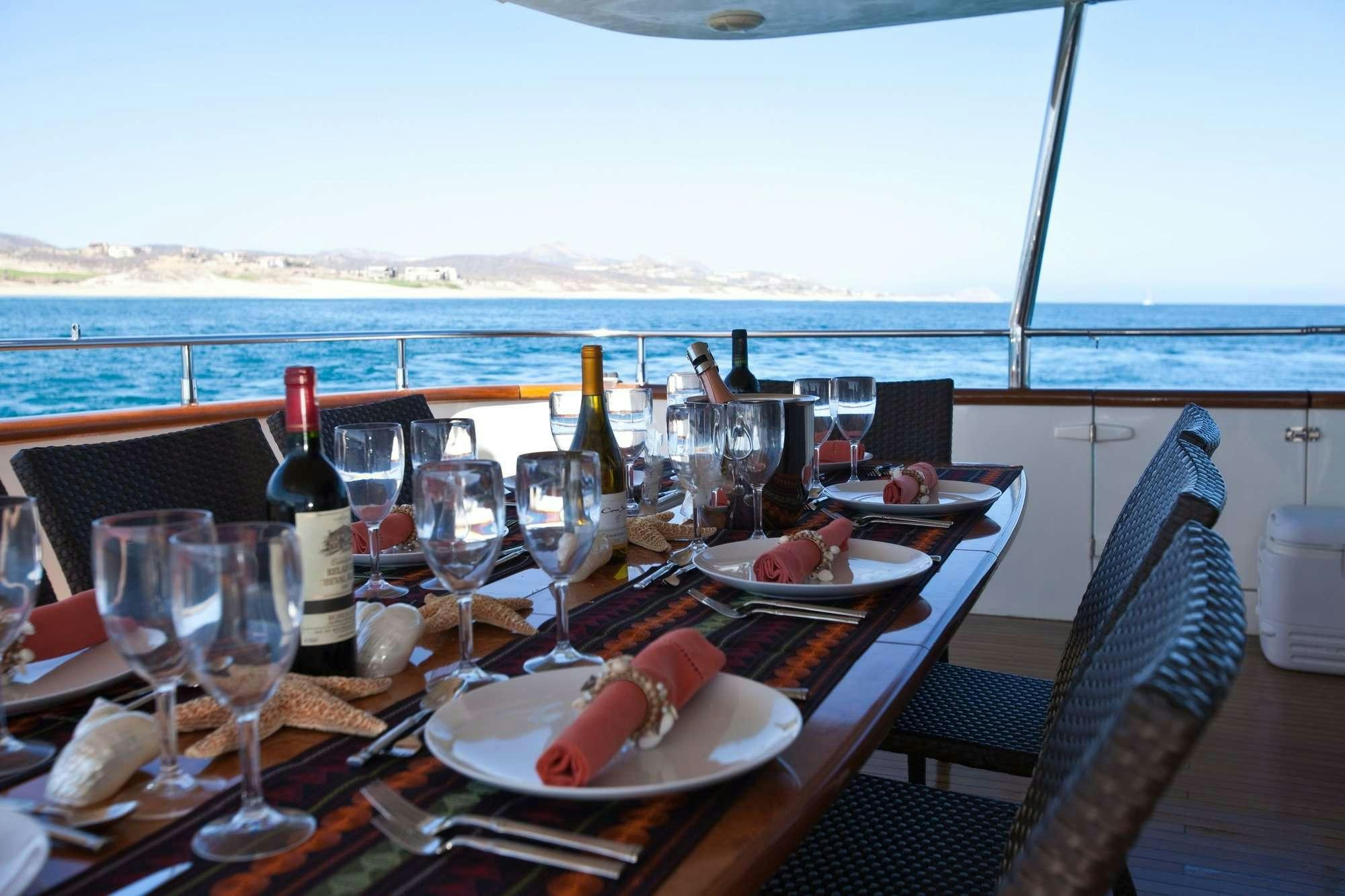 a table with wine glasses and food on it aboard SUPER Yacht for Charter