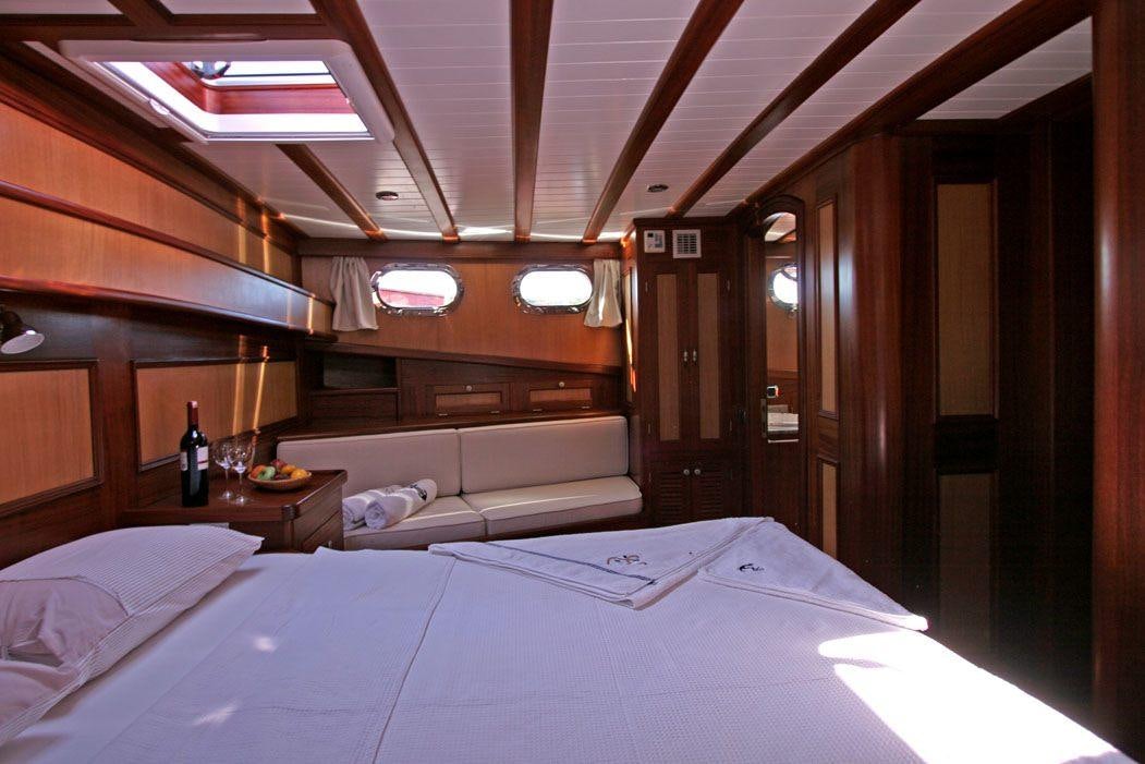 a room with a bed and a table aboard HAYAL 62 Yacht for Charter