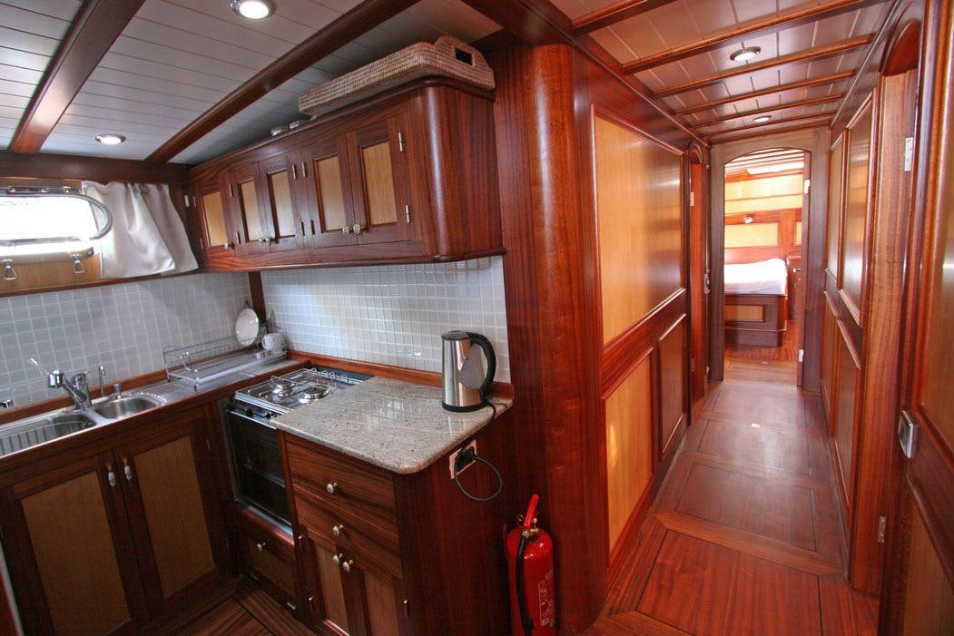 a kitchen with wooden cabinets aboard HAYAL 62 Yacht for Charter