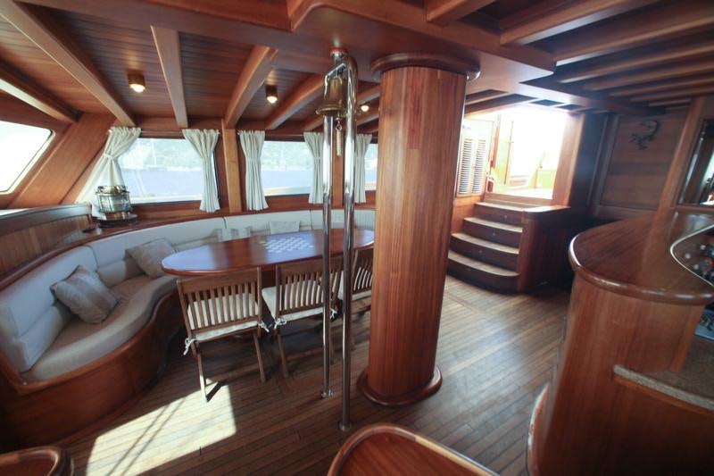 a room with a wood floor and a wood table and chairs aboard EYLUL DENIZ II Yacht for Charter