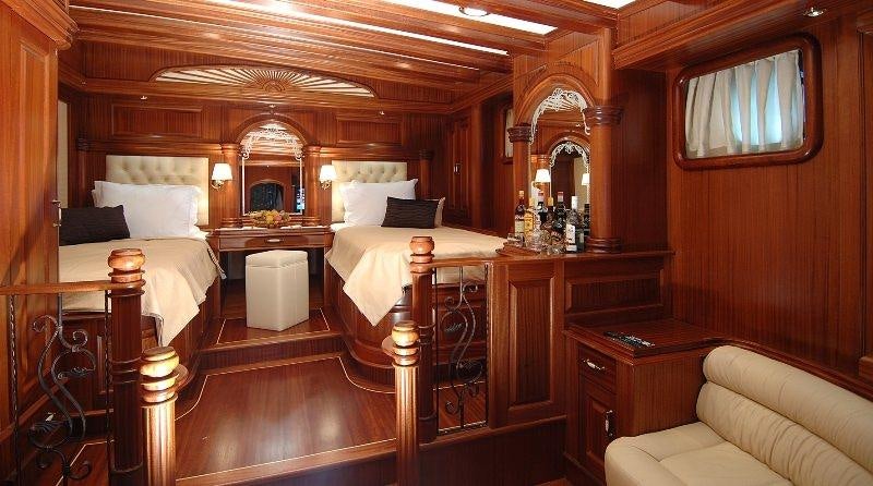 a room with a bed and a mirror aboard MARE NOSTRUM Yacht for Charter