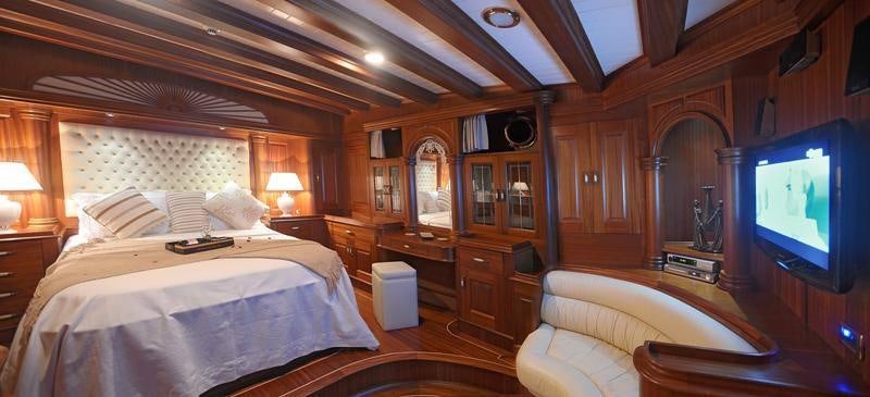 a room with a bed and a television aboard MARE NOSTRUM Yacht for Charter