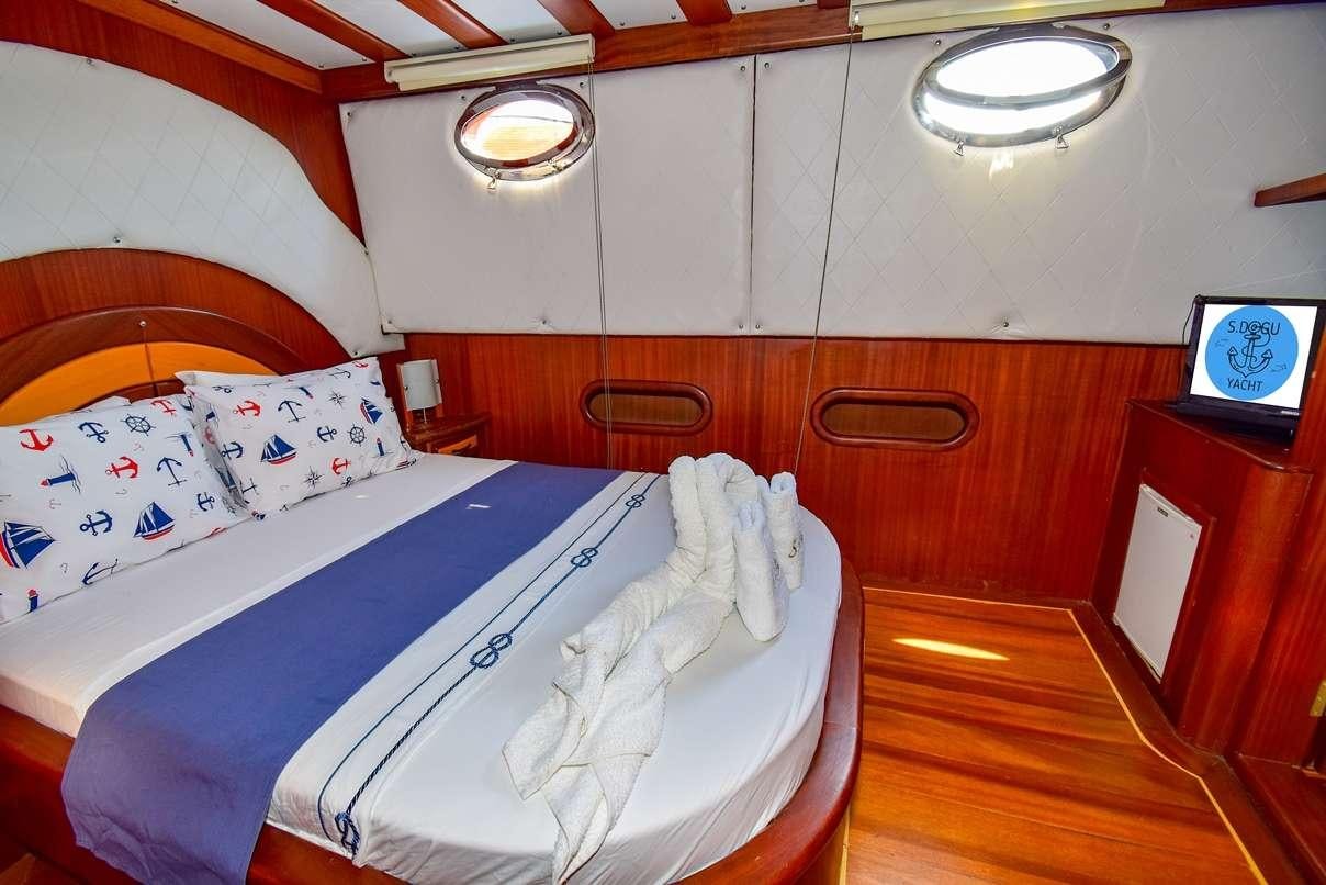 a room with beds and a television aboard S DOGU Yacht for Charter