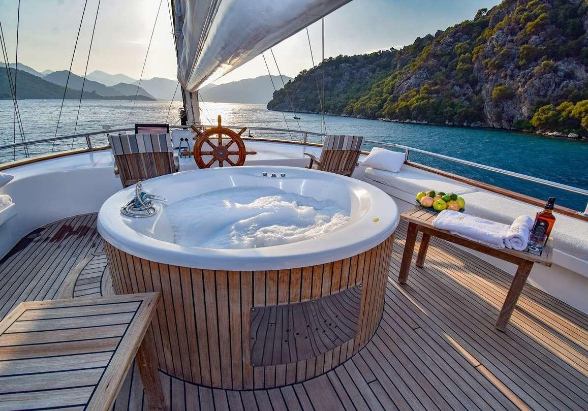 a table and chairs on a deck overlooking a body of water aboard S DOGU Yacht for Charter