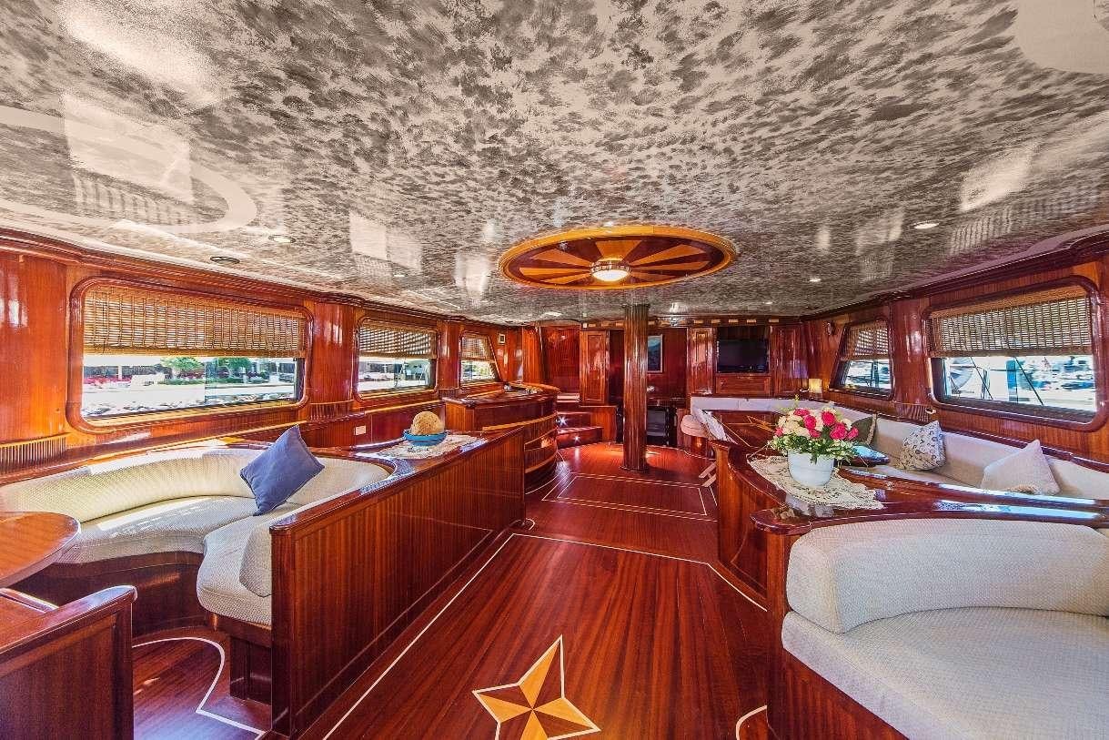 a room with a large chandelier and a table aboard S DOGU Yacht for Charter