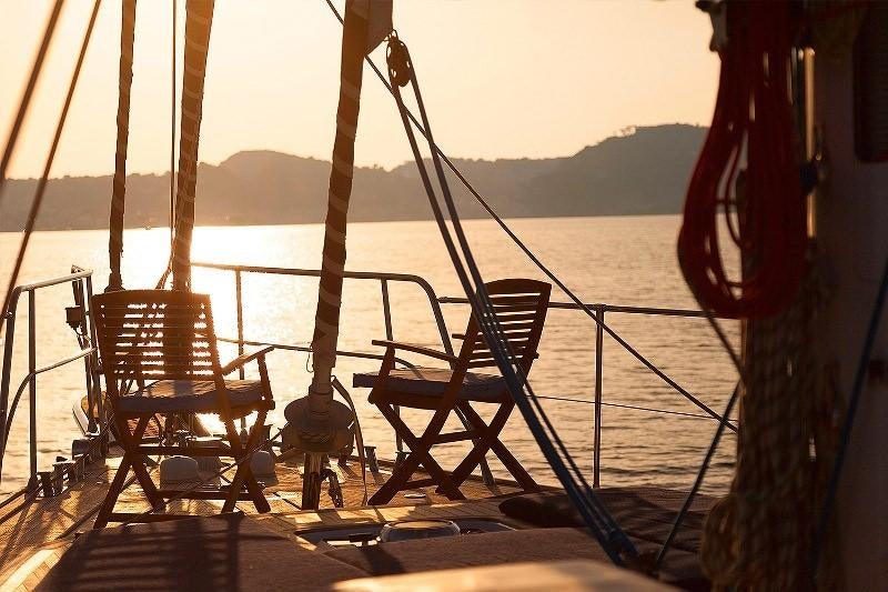 a deck with chairs and a body of water in the background aboard MYOSOTIS Yacht for Charter