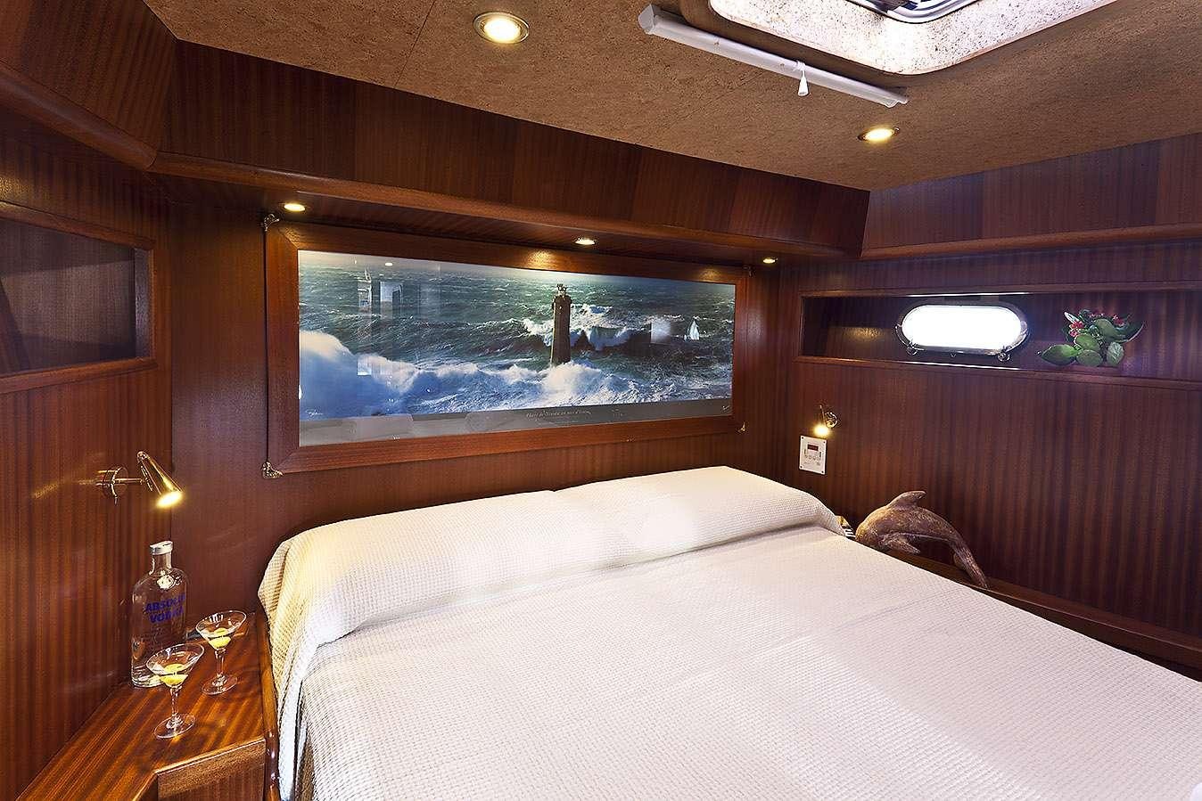 a bed with a large screen aboard MYOSOTIS Yacht for Charter