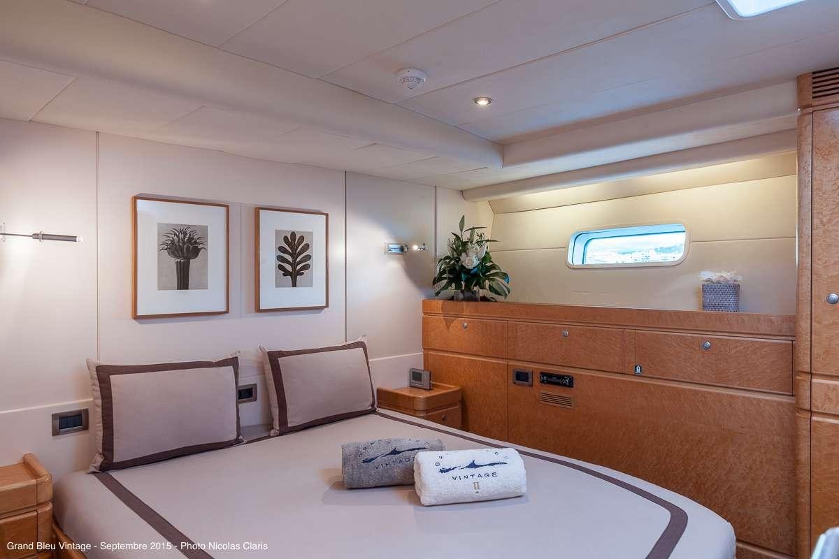 a room with a bed and a desk aboard GRAND BLEU VINTAGE Yacht for Charter