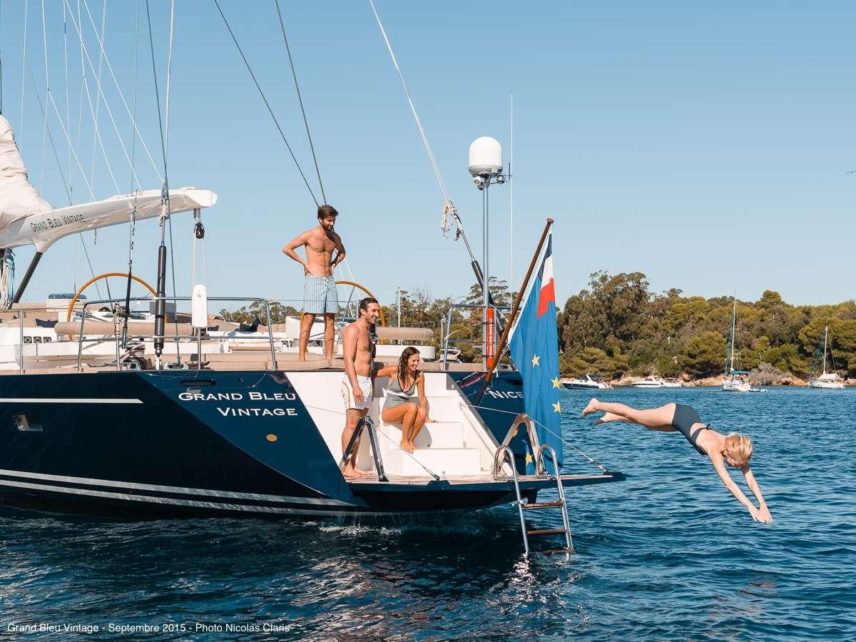 a group of people jumping into a boat aboard GRAND BLEU VINTAGE Yacht for Charter