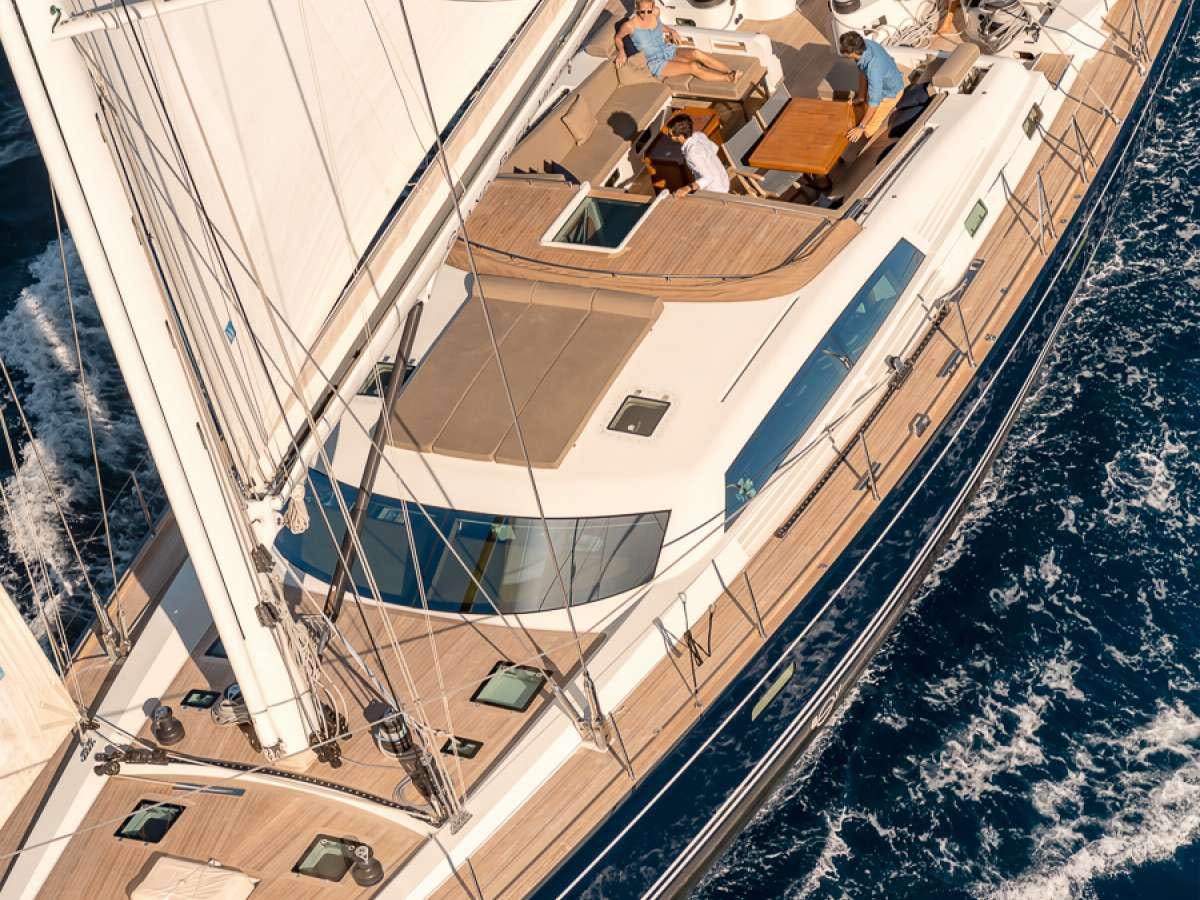 a group of people sitting at a table outside aboard GRAND BLEU VINTAGE Yacht for Charter