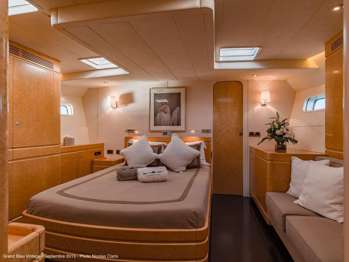 a room with a bed and a couch aboard GRAND BLEU VINTAGE Yacht for Charter