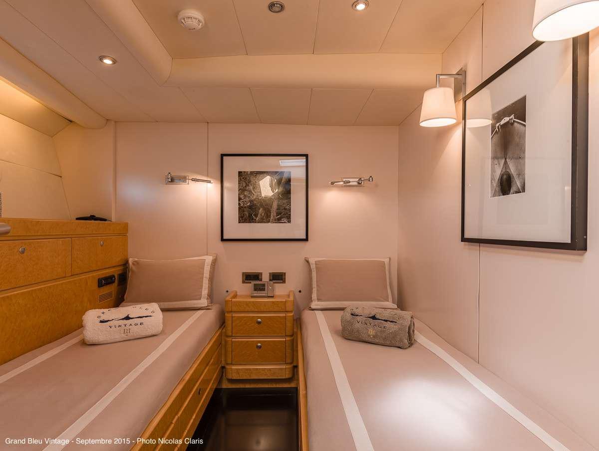 a room with a bed and a desk aboard GRAND BLEU VINTAGE Yacht for Charter