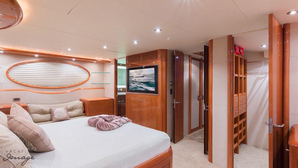 a bedroom with a bed and a television aboard CHIP Yacht for Charter