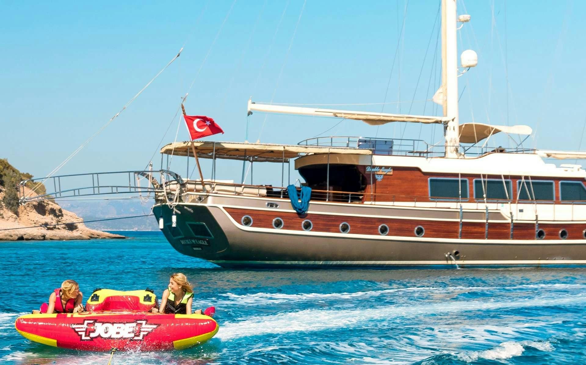 a boat and a couple of people in the water aboard MEIRA Yacht for Charter