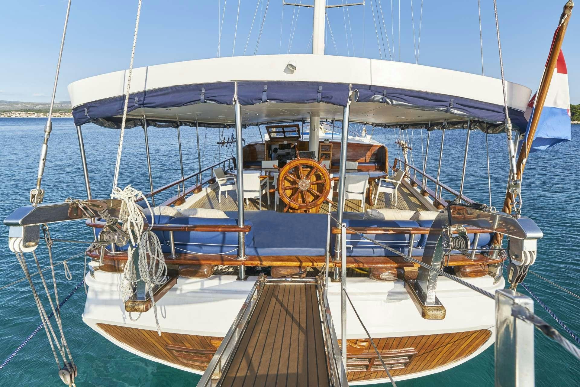 a boat with a blue and white striped canopy aboard PERLA Yacht for Charter